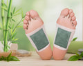Two feet with green patches on toes, next to a bamboo plant.